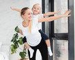 © FreepikCompany - Front view of happy mother and daughter at home exercising