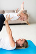 © FreepikCompany - Side view of mother on yoga mat lifting up happy daughter