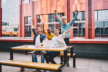 Overjoyed Diverse Team Of Male And Female Employees Celebrating Completing Startup Implementation Rising Hands Smiling, Happy Hipster Guys Students Amazed With Getting Good News About Victory