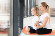 © FreepikCompany - Side view of mother doing yoga with daughter at home