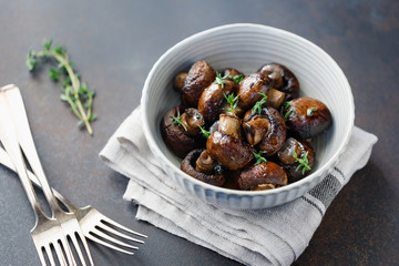 Wall Mural - Grilled champignons with thyme in a ceramic bowl. Simple taste recipe.