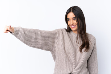 Wall Mural - Young brunette woman over isolated white background giving a thumbs up gesture