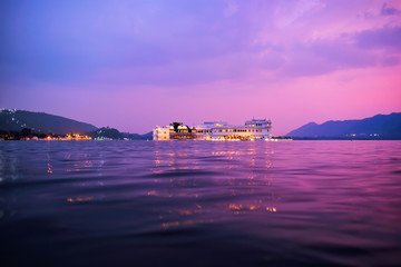 Fototapete - Romantic luxury India travel tourism - Lake Palace (Jag Niwas) complex on Lake Pichola on sunset in twilight with dramatic sky, Udaipur, Rajasthan, India