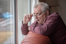 Shocked Senior Man Looking Out Of Window, Nosy Neighbor