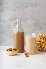 Wall Mural - Chocolate almond milk with a bowl of raw almonds. Healthy vegan protein drink. Dairy alternative