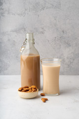 Wall Mural - Chocolate almond milk with a bowl of raw almonds. Healthy vegan protein drink. Dairy alternative