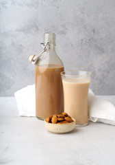 Wall Mural - Chocolate almond milk with a bowl of raw almonds. Healthy vegan protein drink. Dairy alternative