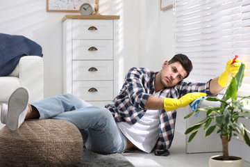 Wall Mural - Lazy man procrastinating while cleaning at home