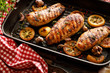 Grilled chicken breasts with thyme, garlic and lemon slices on a grill pan on a wooden background, close up