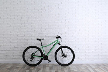 Canvas Print - Modern green bicycle near white brick wall. Space for text