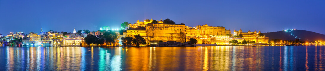 Fototapete - Panorama of famous romantic luxury Rajasthan indian tourist landmark - Udaipur City Palace in the evening twilight with dramatic sky - panoramic view. Udaipur, Rajasthan, India
