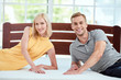 © Friends Stock - Choosing right mattress. Portrait of beautiful and happy young couple testing a new ergonomic mattress for their bed and smiling at camera
