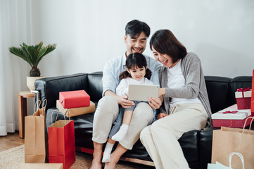 Wall Mural - Mom and Dad and daughter at home using a Tablet PC