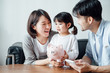 © JodieWang - Mom and Dad and daughter at home, the number of coins