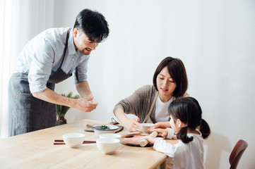 Wall Mural - Mom and Dad and daughter at home dumplings