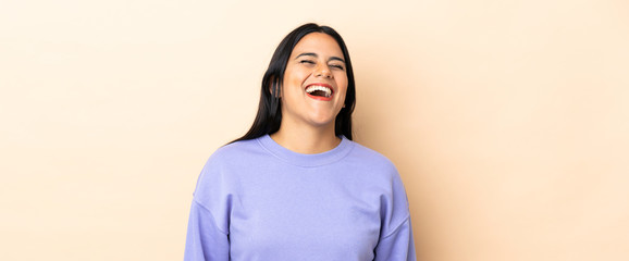 Young latin woman woman over isolated background laughing