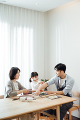 Mom and Dad and daughter at home dumplings