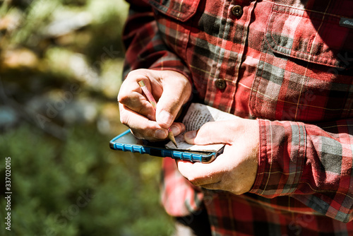 Fotografía A man finding a geocache in the forest with gps