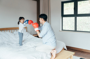 Wall Mural - Dad and daughter playing in bed Boxing