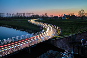 Wall Mural - Curve light trails on country road in the landscape of the province of Groningen, The Netherlands