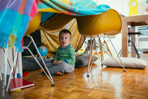Fotografía little boy playing in his built indoor fort in living room