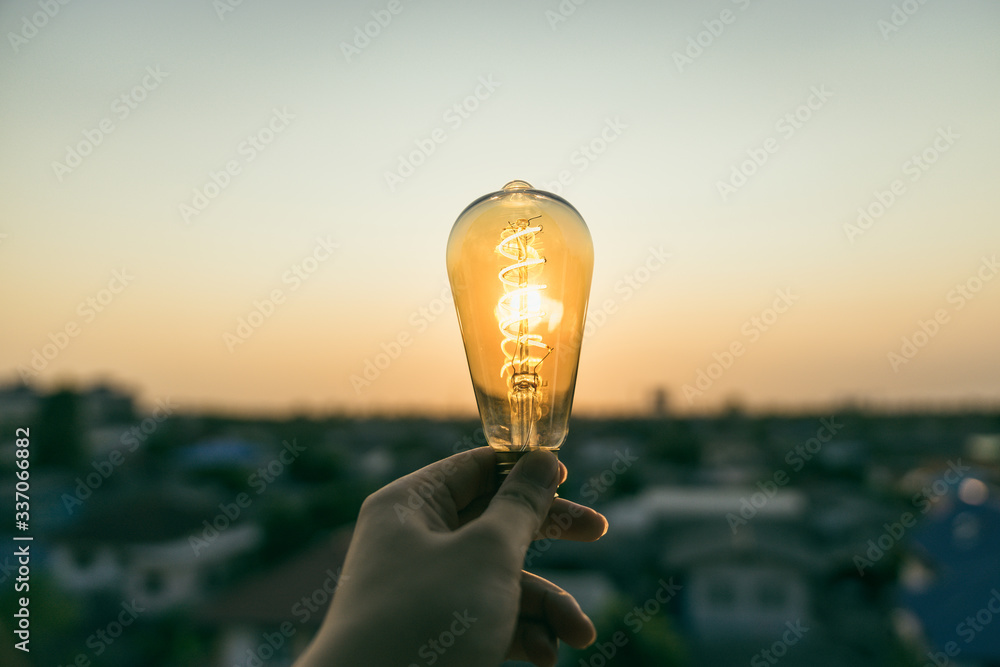Hand business man holding light bulb.Alternative energy, idea, saving electricity innovation and inspiration concepts.. - obrazy, fototapety, plakaty 