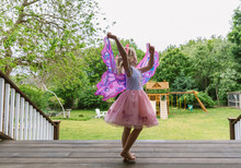 Young Fairy Girl Dancing On Porch In Butterfly Costume