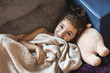 © Ira Efremova Photography/Stocksy - Cute little girl laying on a couch with her bear under a blanket