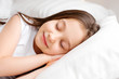 © Tina kids photo - Little brunette girl sleeps sweetly in bed with white linen. space for text. healthy baby's sleep