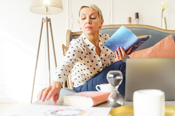 Wall Mural - Woman with a book staring at the table