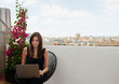 © guille Faingold/Stocksy - Business lady with laptop on balcony.