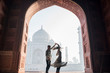travel couple dancing in front of the taj mahal