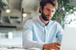 © fotofabrika - Businessman in shirt working on his laptop in an office. Open space office