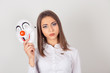 © hbrh - Portrait young upset worried woman with sad expression holding a clown mask expressing cheerfulness happiness isolated on white wall background. Human facial expression feeling