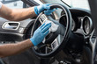 © Joshua - A bearded brown haired man wearing a baseball cap uses alcohol wipes to sterilize the front driver seat, steering wheel, and surrounding areas from any lingering virus strains or germs that are inside
