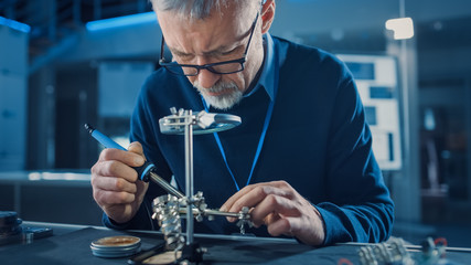 Poster - Electronics Maintenance Engineer Soldering Motherboard, Microchip and Circuit Board, Looking through Magnifying Glass, Consults Personal Computer. Electronics Repair and Testing