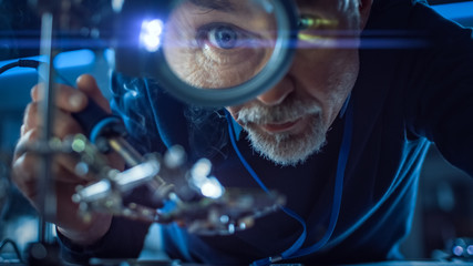 Fototapete - Electronics Maintenance and Repair Engineer Soldering Motherboard, Microchip and Circuit Board, Looking through Magnifying Glass. Conceptual Shot: Close-up Low Angle Magnifying Eye and Face