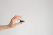 man holds usb flash drive in his hand with his fingertips on a white background
