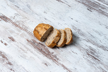 Top view of freshly baked healthy sliced loaf of multi-grain seedy bread on rustic wooden table. Homemade sliced bread close-up. Baking and home bread making background, concept, copy space