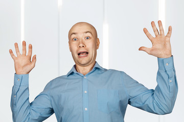 Portrait White bald man in blue shirt got scared and hands up