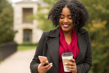 Wall Mural - African American Woman texting and drinking coffee.