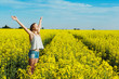 © Tatiana Bobrova - Happy girl with wide open hands in a yellow flowering field on a sunny day experiences a feeling of joy and freedom