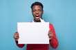 © Viktor Koldunov - African american man holding empty white sign in a studio blue background. studio shot