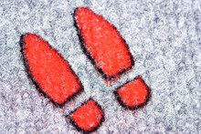 High Angle Close-up Of Red Footprints On Rug