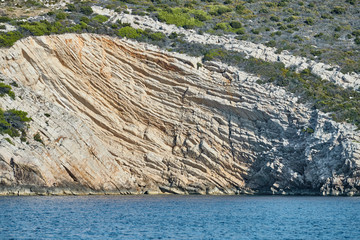 Wall Mural - Beautiful high cliff with caves and hanging rocks of a mountain in Adriatic sea, a crevice, colorful