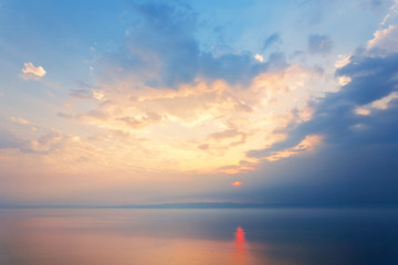 Wall Mural - baikal lake on a foggy summer evening. beautiful sky landscape with pink and golden clouds over blue