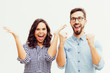 © Mangostar - Happy excited couple rejoicing at good news, making winner gestures, celebrating success. Young woman in casual and man in glasses standing isolated over white background. Good news concept