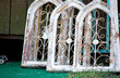 Arched wooden windows for sale at an outdoor  salvage yard