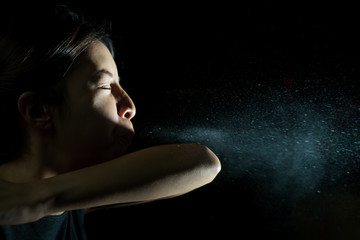 Wall Mural - Woman coughing or sneezing in her elbow. Concept of stop spread of the virus. Spray infection