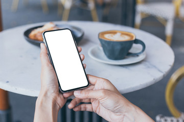 cell phone Mockup image blank white screen.woman hand holding texting using mobile on desk at coffee shop.background empty space for advertise text.people contact marketing business,technology